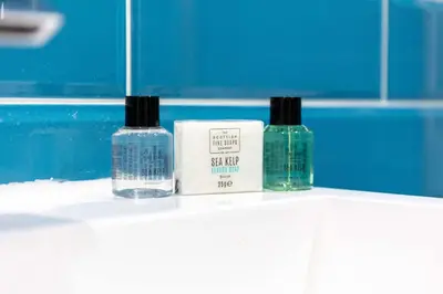 three bottles of soap sitting on a shelf in a bathroom at Albyn Retreat - Donnini Apartments in Prestwick