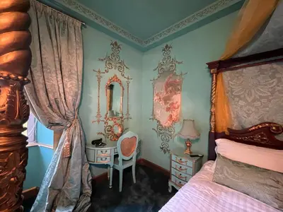 a bedroom with a bed and a desk and a mirror at Craigielands House in Beattock