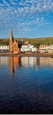 a church sitting in the middle of a body of water at Largs Sandringham Apartment in Largs