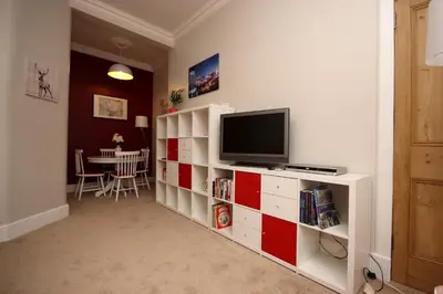 a living room with a television on a red and white cabinet at Hamish's Hame Edinburgh Licence No EH 69774 R Energy Rating C in Edinburgh