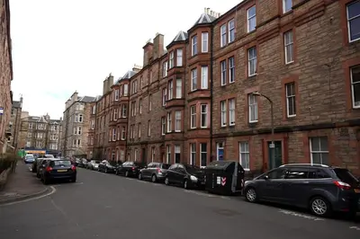 a row of cars parked on a street next to buildings at Hamish's Hame Edinburgh Licence No EH 69774 R Energy Rating C in Edinburgh