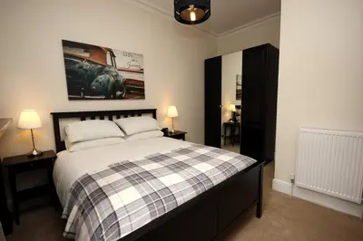 a bedroom with a bed and two lamps and a painting at Hamish's Hame Edinburgh Licence No EH 69774 R Energy Rating C in Edinburgh