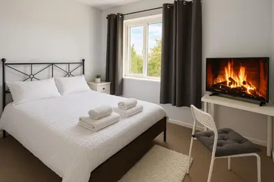 a bedroom with a bed with a fireplace and a tv at Cozy 2BR Flat Near City Centre Free Parking Fast Wifi in Edinburgh