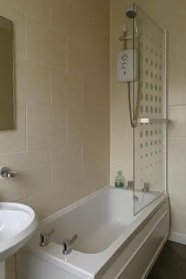 a bathroom with a bath tub and a sink at Cozy 2BR Flat Near City Centre Free Parking Fast Wifi in Edinburgh