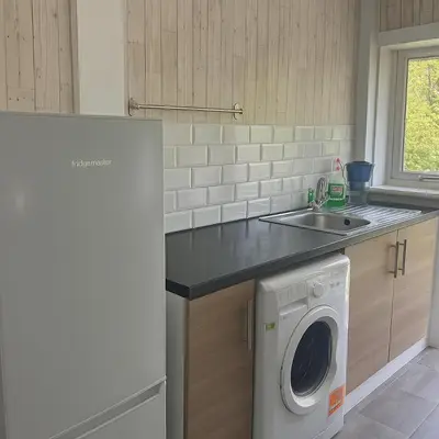a kitchen with a washing machine and a sink at Cozy 2BR Flat Near City Centre Free Parking Fast Wifi in Edinburgh