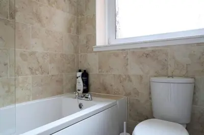 a bathroom with a toilet and a tub and a sink at Edinburgh Family-Friendly Flat Walkable from Princess street in Edinburgh