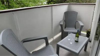 two chairs and a table with a bottle of wine on a balcony at Edinburgh Family-Friendly Flat Walkable from Princess street in Edinburgh