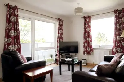 a living room with two couches and a television at Edinburgh Family-Friendly Flat Walkable from Princess street in Edinburgh
