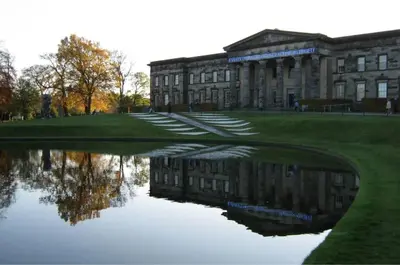 a building with a reflection in a body of water at Edinburgh Family-Friendly Flat Walkable from Princess street in Edinburgh