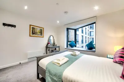a bedroom with a large bed and a window at Lovely 1-Bedroom Unit Near Edinburgh Castle in Edinburgh