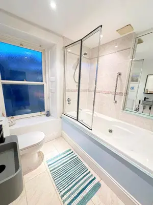 a bathroom with a tub and a toilet and a window at Duplex - City Centre 4-Bed Retreat in Edinburgh