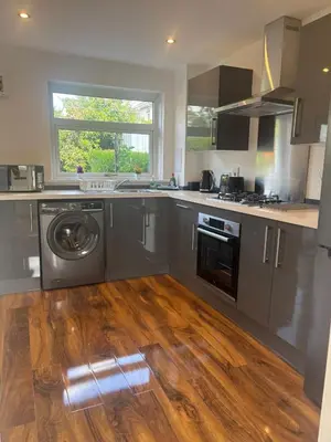 a kitchen with stainless steel appliances and a wooden floor at NEW - 3 Bedroom House in East Kilbride in East Kilbride
