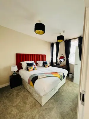 a bedroom with a large bed with a red headboard at The courtyard bar, kitchen, rooms in Falkirk