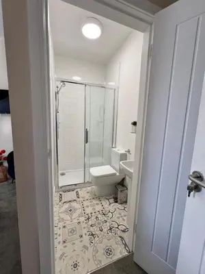 a bathroom with a toilet and a glass shower at The courtyard bar, kitchen, rooms in Falkirk
