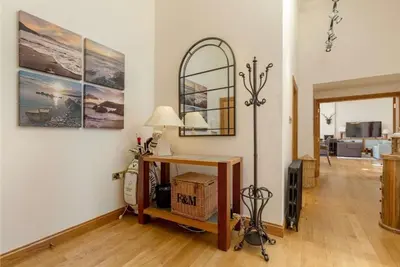 a living room with a table and a lamp at Stunning Flat in Loch Lomond in Luss