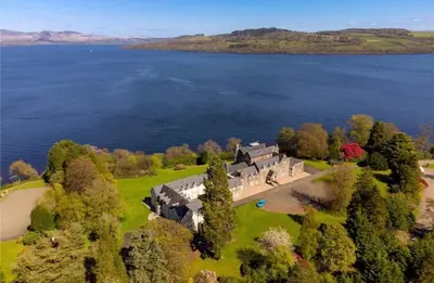 an aerial view of a house on the shore of a lake at Stunning Flat in Loch Lomond in Luss