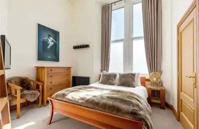 a bedroom with a bed and a window at Stunning Flat in Loch Lomond in Luss