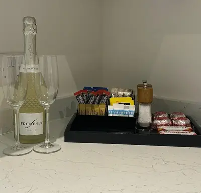 a bottle of wine and two glasses on a counter at The West Wing - 1Bedroom Annexe with parking in Oban
