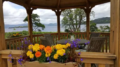 a gazebo with a table with flowers on it at Bruach Lodge in Balloch