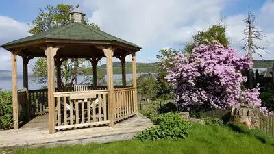 a wooden gazebo in a garden with a tree at Bruach Lodge in Balloch
