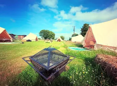 a group of tents in a field with grass at Infinite Sky camping in Moffat