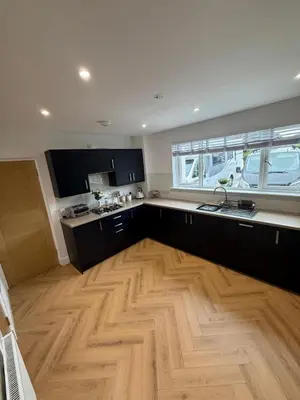a large kitchen with a wooden floor and a sink at Best stay in the bay in Saint Davids