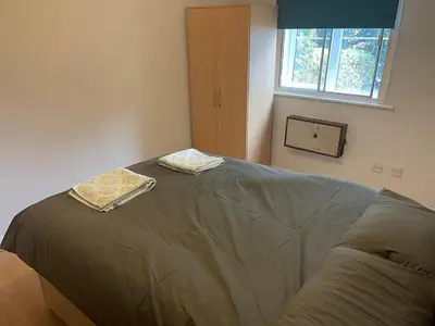 a bed in a room with two towels on it at 2 bed flat - TW7 4NH in Moffat