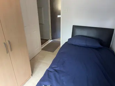 a bedroom with a blue bed and a closet at 2 bed flat - TW7 4NH in Moffat