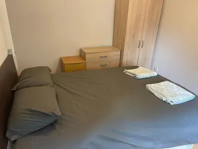 a bedroom with a bed with a brown bedspread and a dresser at 2 bed flat - TW7 4NH in Moffat
