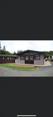 a small building with a lot of windows on it at Rowardennan Rooms in the lodge Lodge no 2 in Rowardennan