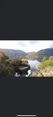 a view of a river with a boat in the water at Rowardennan Rooms in the lodge Lodge no 2 in Rowardennan