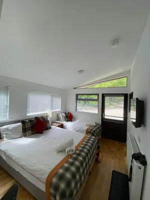 a bedroom with two beds and a couch at Rowardennan Rooms in the lodge Lodge no 2 in Rowardennan