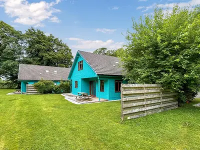 a blue house with a fence in a yard at Foxglove Cottage 2 - Uk50020 in Drymen