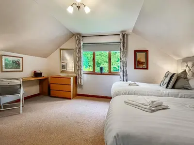 a bedroom with two beds and a desk and a window at Foxglove Cottage 2 - Uk50020 in Drymen