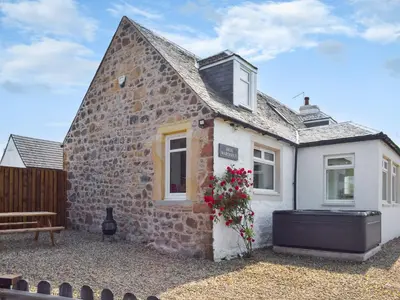 a stone cottage with a bench in front of it at High Wardneuk - Uk47041 in Symington