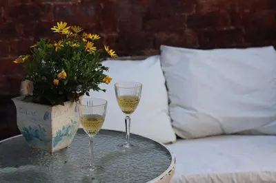 two glasses of wine on a table next to a bed at Filey in Moffat