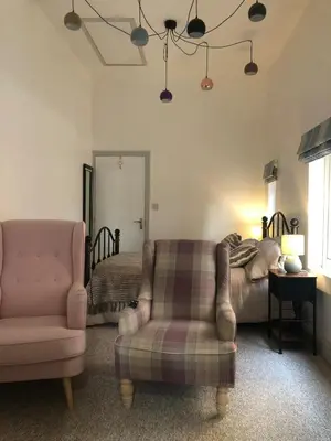 a living room with a chair and a bed at Filey in Moffat