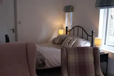 a bedroom with a bed with two lamps and a chair at Filey in Moffat