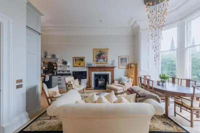 a living room with a white couch and a table at Luxury West End flat with stunning bay window views in Edinburgh