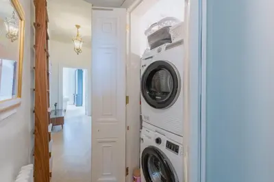 a washer and dryer in a room with a hallway at Luxury West End flat with stunning bay window views in Edinburgh