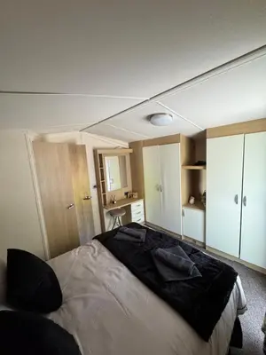 a bedroom with a large bed and a desk at Moselle - 6 Squirrel View in Ballantrae