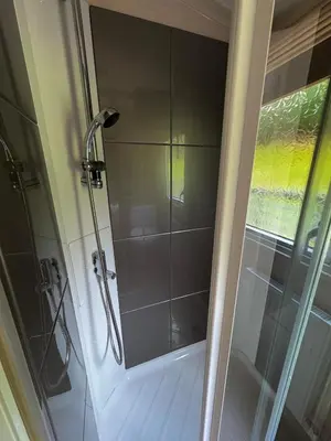 a shower with a glass door in a bathroom at Moselle - 6 Squirrel View in Ballantrae