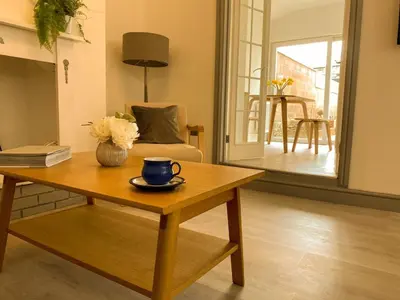 a living room with a coffee table with a cup on it at Modern 2Bed Garden Apartment in Heart of Penarth in Moffat