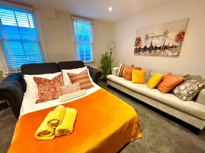 a bedroom with a large bed and a couch at Private 1 bed flat Knightsbridge, Chelsea in Moffat