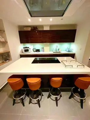 a kitchen with a counter with four bar stools at Private 1 bed flat Knightsbridge, Chelsea in Moffat