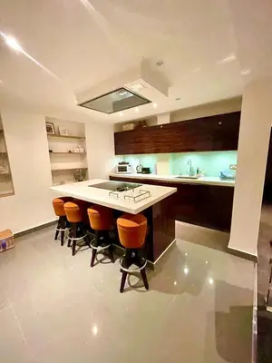 a kitchen with a island with bar stools in it at Private 1 bed flat Knightsbridge, Chelsea in Moffat