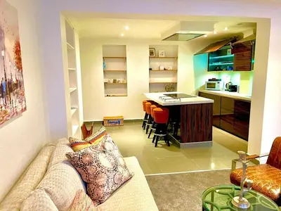 a living room with a couch and a kitchen at Private 1 bed flat Knightsbridge, Chelsea in Moffat