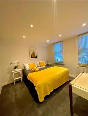 a bedroom with a bed with a yellow blanket at Private 1 bed flat Knightsbridge, Chelsea in Moffat