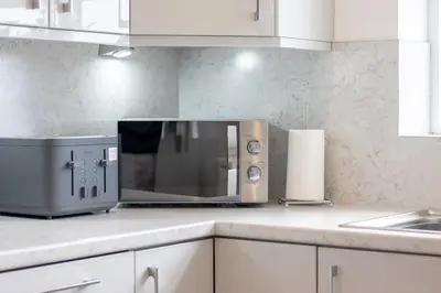 a microwave oven sitting on a counter in a kitchen at The Well - 3 bedroom apartment in Motherwell