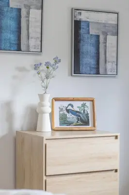 a picture of a bird on a dresser with two pictures at Leven Loft - 2 Bed Flat in Coatbridge in Coatbridge